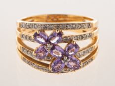 A 14ct gold diamond and pink sapphire flower ring, the ring designed as four conjoined bands,