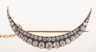 A Victorian diamond crescent moon brooch, set with two rows of graduated old-cut diamonds,
