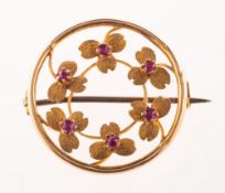 An antique ruby flower garland brooch, a circular mount with an inner garland of floral motifs,