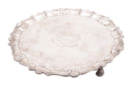 A George II silver salver, shaped circular outline, with a husk and scroll border,