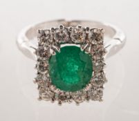 An emerald and diamond cluster ring, of rectangular form,