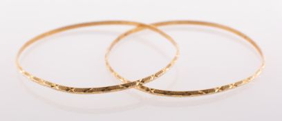 Two carved pattern bangles, each bangle carved with a similar textured and diamond cut pattern,