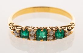 An emerald and diamond gypsy ring, claw set with three square-cut emeralds,