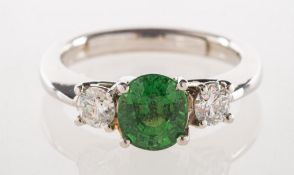 A platinum tsavorite garnet and diamond three stone ring, a modern three stone ring,