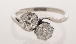 A diamond 'toi et moi' ring, claw set on a twist designed band with two old mine-cut diamonds,