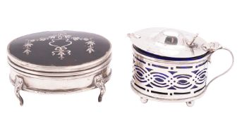 A George V silver mustard pot, oval form, with pierced sides and on ball feet (blue glass liner),