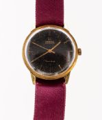 Omega, a gold-plated wristwatch the round, black dial having raised gold baton numerals,