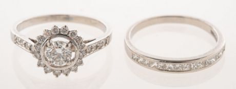 A diamond halo ring and a diamond half eternity ring,