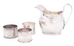 An Edwardian silver milk jug, shaped oval form, with a loop handle and a flat base,