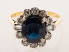 A sapphire and diamond cluster ring, claw set with an oval-cut dark blue sapphire, sapphire approx.