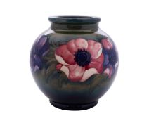 A Walter Moorcroft pottery vase of globular form tube lined in the Anemone pattern reserved on a