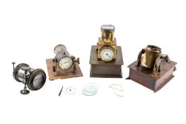 A group of three early 20th century clock projectors and a magic lantern lens.