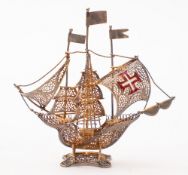 A Portuguese white metal and enamel filigree model of a galleon.