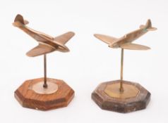 Two brass models of Spitfires. Set in a dive on brass stands and wooden plinths, 16cm high.