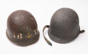 Two United States WWII M1 steel helmets.