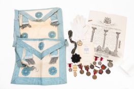A Silver gilt Masonic jewel, together with two Masonic aprons and regalia in a brown leather case,