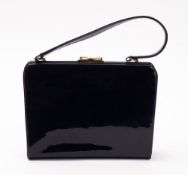 A navy blue patent leather Waldy Bag, with gold toned hardware and bow clasp, 23cm x 18cm x 6cm.