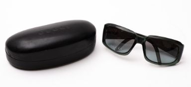A pair of Gucci sunglasses. Product number GG1402/S, in black and in a Gucci case.