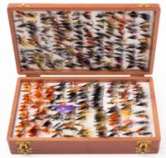 A collection of trout flies in a mahogany case.