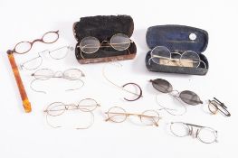 A collection of various early 20th century spectacles, including several tortoise shell examples.