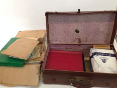 An all world accumulation of stamps in a suitcase and a plastic folder.