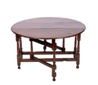 An 18th century oak gateleg table, with an oval hinged top,