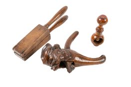 A carved and stained treen nutcracker in the form of a caricature head of an old man,