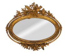 A 19th century carved giltwood and gesso oval wall mirror, the cresting with birds,