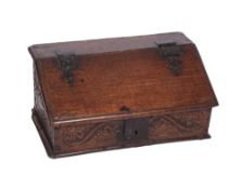 A 17th Century carved oak writing desk, the sloping hinged,