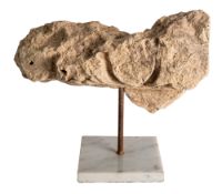 A carved limestone fragment of entablature, perhaps Roman;