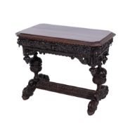 A Victorian carved dark oak side table, the top with foliate edge and canted angles,
