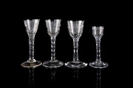 Two similar English wine glasses with rounded funnel shaped bowls engraved and cut with flowers