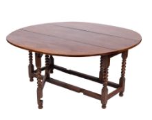 An 18th century walnut circular gateleg dining table, with a hinged top,