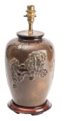 A Japanese patinated bronze table lamp, late Meiji/20th century decorated in relief with a Shishi,