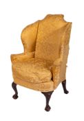 A carved beechwood wing frame armchair in the George II taste,