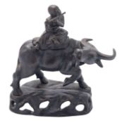 A Chinese bronze boy on a water buffalo, 20th century the boy playing a flute, on rocky mound base,