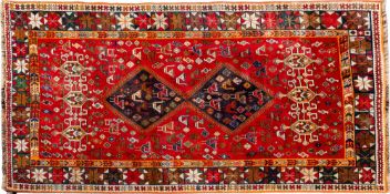 A Qashgai carpet, of small size, the red field with twin shaded hooked lozenge medallions,
