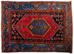 A Hamadan rug, the brick red stepped and pointed hexagonal field with scattered designs,
