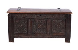 An 18th Century later carved oak coffer, the slightly domed hinged top with strap work hinges,