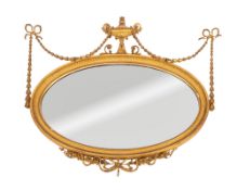 A giltwood and gesso oval mirror in the Regency style, with urn and ribbon tied husk swag cresting,