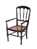 A Childs French ebonised and gilt decorated elbow chair, the cartouche back with spindle splats,