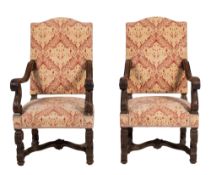 A pair of carved beech wood open arm chairs in the late 17th century style,