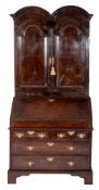 An early 18th century walnut double dome bureau cabinet,