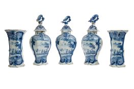 A Dutch Delft garniture comprising three jars and covers of flattened baluster form,