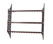A Georgian mahogany three tier hanging open bookcase, with pierced lattice ends and shelves,