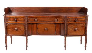 A Regency Irish mahogany sideboard, of concave fronted breakfront outline,