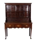 A late 18th /early 19th century oak dresser, the shelved superstructure with a moulded cornice,