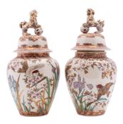 A pair of Japanese Satsuma jars and covers, Meiji period with shishi and pierced ball finials,