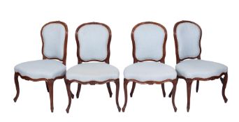 A set of four early 19th century French carved walnut salon chairs in the Louis XV taste with