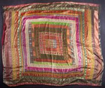 An Indian silk blanket or wall hanging formed from bright bands containing foliage, flowers, birds,